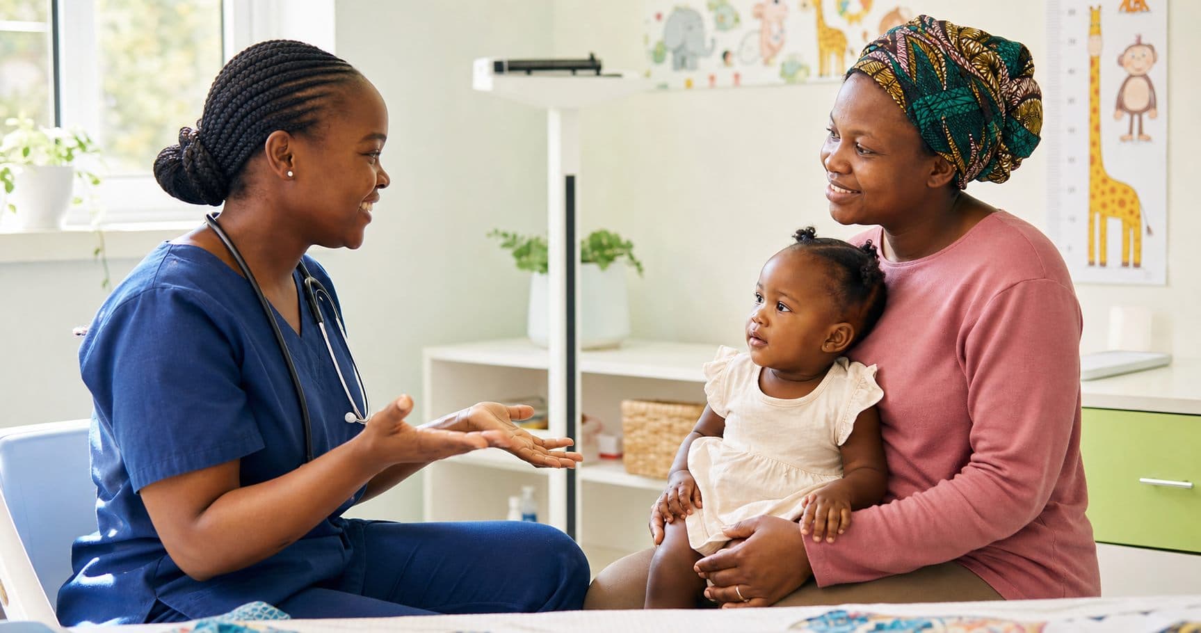 African nurse speaking with a mother holding her child in a child welfare clinic